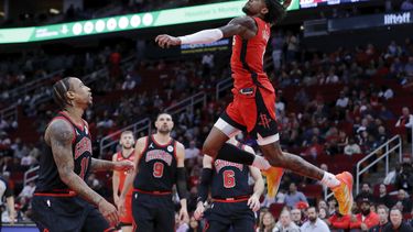 El base de los Rockets de Houston Jalen Green clava el balón mientras lo observan el alero de los Bulls de Chicago DeMar DeRozan, el pívot Nikola Vucevic y el base Alex Caruso el jueves 21 de marzo del 2024. (AP Foto/Michael Wyke)