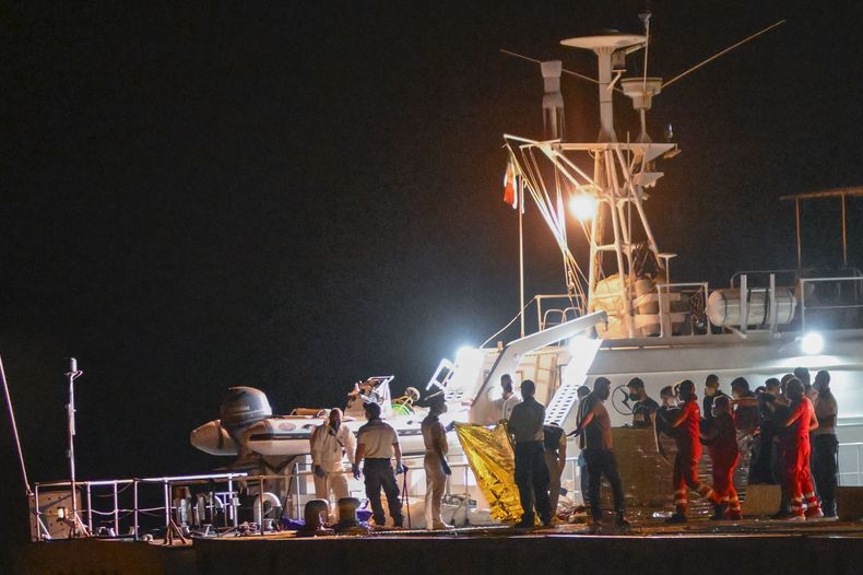 Los cuerpos de unos 64 migrantes desaparecidos en el mar Mediterráneo tras el naufragio de su barco frente a las costas de sur de Italia son desembarcados en la ciudad portuaria de Roccella Ionica, en el sur de Italia, la madrugada del miércoles 19 de junio de 2024.. (AP Foto/Valeria Ferraro)