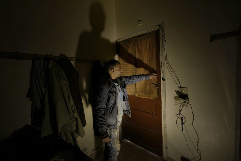 Hussein Arbeeni, de 41 años, muestra cómo bloqueó con cintas la puerta de una habitación en la que 23 personas se encerraron para evitar la fuga del sarín lanzado durante un ataque con armas químicas en 2013 del que se culpó a las fuerzas del entonces presidente Bashar Assad, en el barrio de Zamalka, a las afueras de Damasco (Siria), miércoles 25 de diciembre de 2024. (AP foto/Hussein Malla)