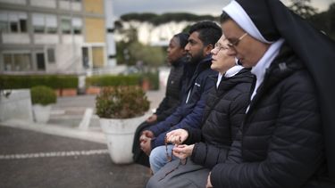 Monjas rezan por Francisco frente a la estatua del papa Juan Pablo II, en el exterior del policlínico Agostino Gemelli de Roma, el 20 de febrero de 2025. El pontífice argentino está ingresado en el centro desde el 14 de febrero. (AP Foto/Alessandra Tarantino)