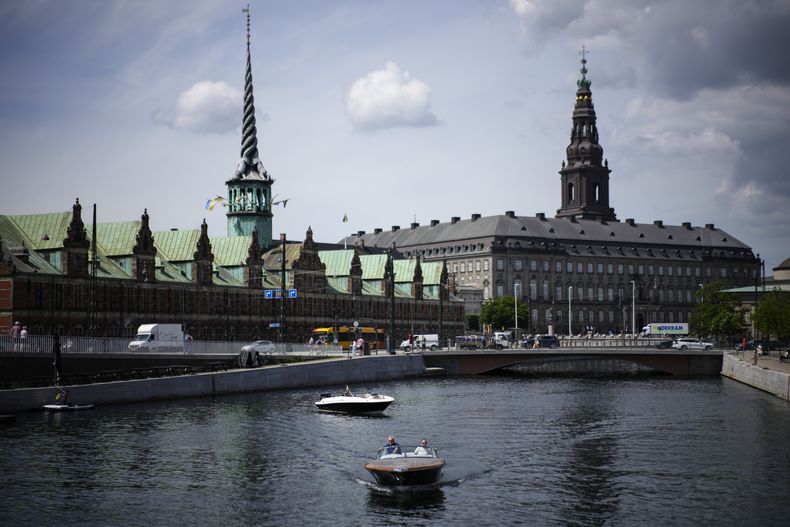 ARCHIVO - Un barco vadea el río Nyhavn, con el edificio de la Antigua Bolsa de Valores al fondo, en Copenhague, Dinamarca, el 29 de junio de 2022. (AP Foto/Daniel Cole, Archivo)