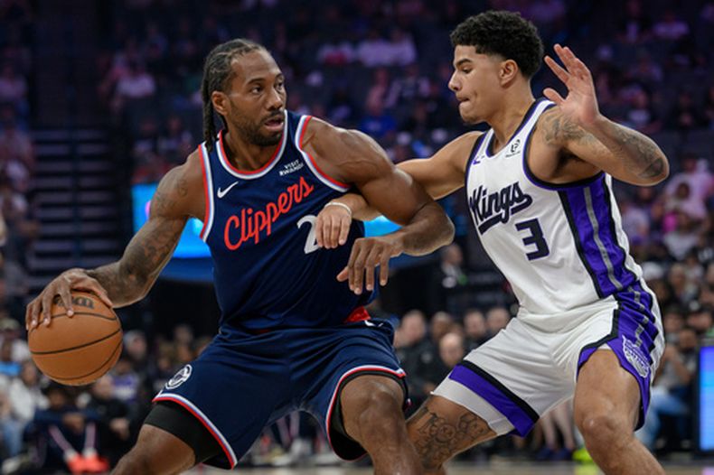 Kawhi Leonard (2), delantero de el Clippers de Los Ángeles, es marcado por Killian Hayes (3), guardia de los Kings de Sacramento, durante la primera mitad de un juego de baloncesto de la NBA en Sacramento, California, el domingo 5 de abril de 2026. (Foto AP/Randall Benton)