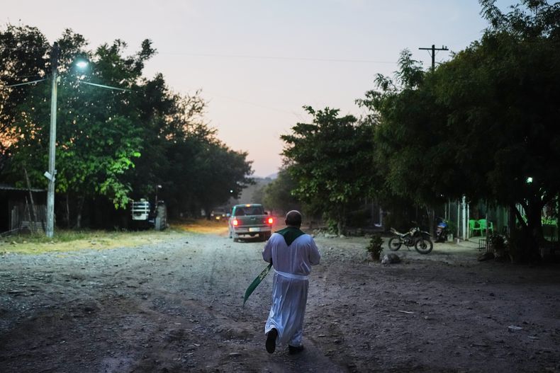 El sacerdote Gilberto Vergara camina hacia una casa para bendecir a una persona en Apatzingan, en el estado de Michoacán, México, el 19 de noviembre de 2025. (AP Foto/Eduardo Verdugo)