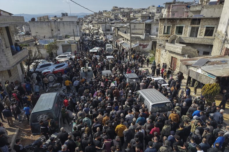 Familiares y vecinos asisten a la procesión fúnebre de cuatro miembros de las fuerzas de seguridad sirias muertos en enfrentamientos con leales al derrocado presidente Bashar Assad en la costa de Siria, en la aldea de Al-Janoudiya, al oeste de Idlib, el sábado 8 de marzo de 2025. (Foto AP/Omar Albam)
