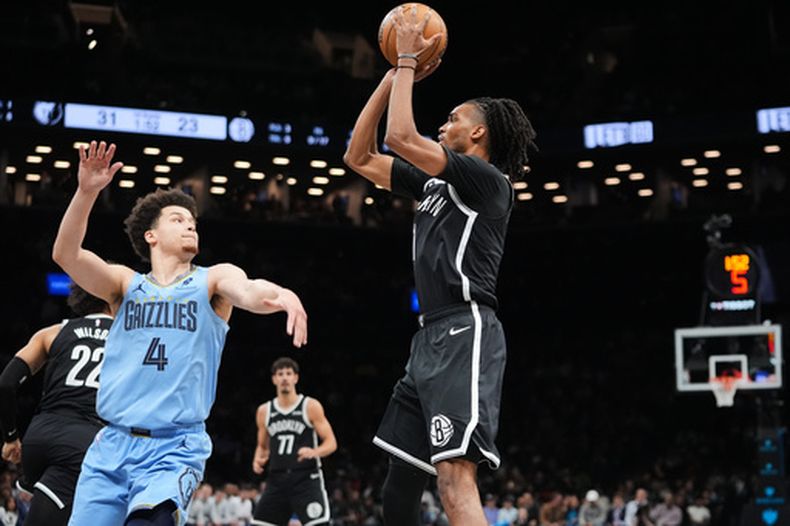 Ziaire Williams (1), de los Nets de Brooklyn, lanza sobre Walter Clayton Jr. (4), de los Grizzlies de Memphis, durante la primera mitad de un juego de baloncesto de la NBA, el lunes 9 de marzo de 2026, en Nueva York. (Foto AP/Frank Franklin II)