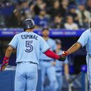 Santiago Espinal (5) de los Azulejos de Toronto celebra con su compañero Vladimir Guerrero Jr. (27) tras anotar una carrera ante los Medias Blancas de Chicago, el miércoles 26 de abril de 2023, en Toronto. (Andrew Lahodynskyj/The Canadian Press vía AP)
