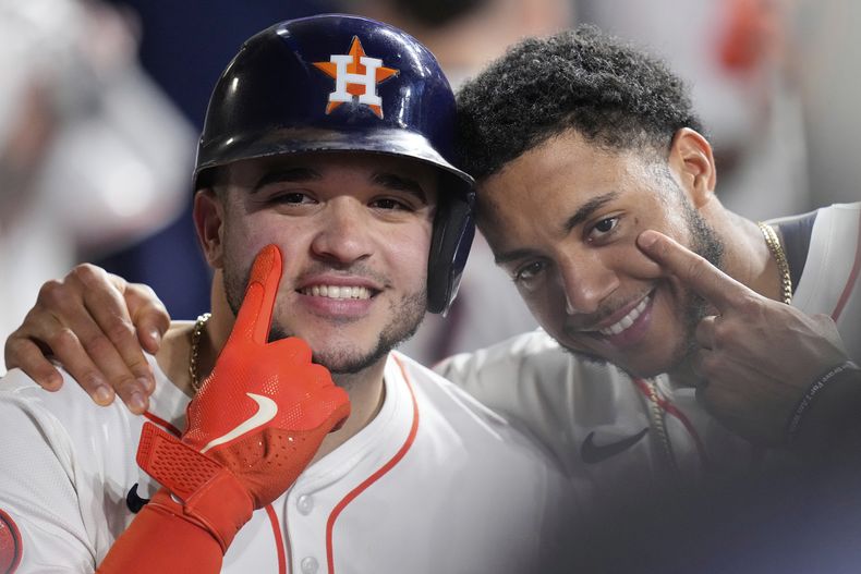 Los dominicanos Yainer Díaz (izquierda) y Jeremy Peña, de los Astros de Houston, festejan luego que el primer conectó un jonrón ante los Medias Rojas de Boston, el miércoles 13 de agosto de 2025 (AP Foto/David J. Phillip)