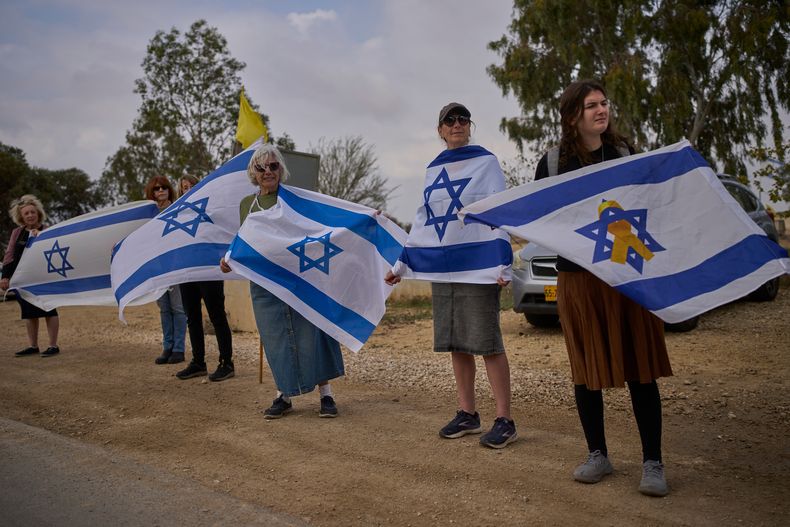 Israelíes esperan junto a una carretera por la que pasará un cortejo fúnebre con el ataúd del rehén asesinado Dror Or, después de que su cuerpo fuera devuelto desde Gaza dentro de un acuerdo de cese el fuego entre Israel y Hamás, en el kibutz Beeri, el domingo 30 de noviembre de 2025. (AP Foto/Ohad Zwigenberg)