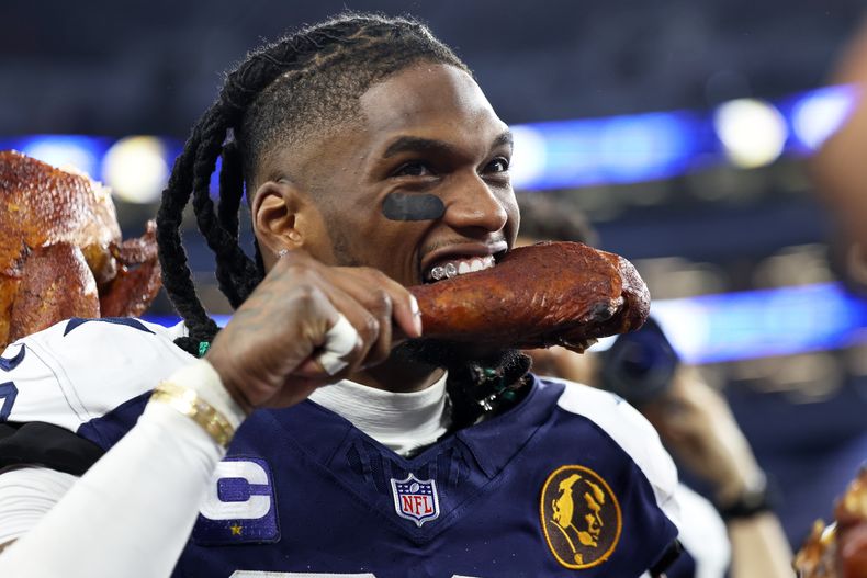 CeeDee Lamb, receptor de los Cowboys de Dallas, festeja con una pierna de pavo, luego del triunfo sobre los Chiefs de Kansas City en el Día de Acción de Gracias, el jueves 27 de noviembre de 2025 (AP Foto/Gareth Patterson)