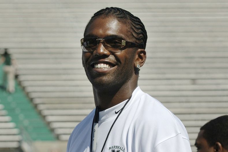 ARCHIVO - Randy Moss, ex jugador de la NFL y actual analista de ESPN, saluda a aficionados previo a ser entrenador honorario durante un partido de la universidad de Marshall, en el juego anual Green-White, el sábado 22 de abril 2006, en Huntington, Virginia del Oeste. (AP Foto/Jeff Gentner, Archivo)