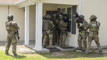 Miembros de un equipo de respuesta especial del Servicio de Control de Inmigración y Aduanas (ICE) muestran cómo entran a una vivienda para dar con una persona buscada, en el centro de formación federal en Brunswick, Georgia, el 21 de agosto de 2025. (AP Foto/Fran Ruchalski)
