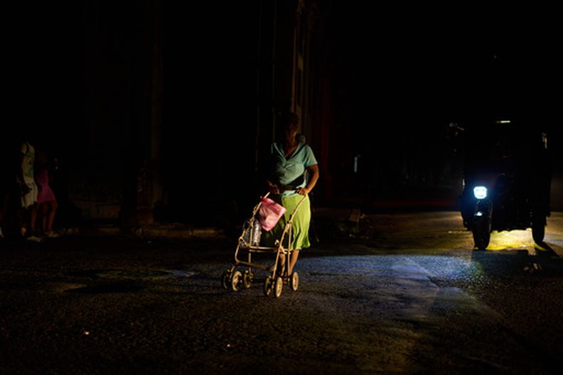Una mujer empuja un carro al cruzar la calle durante un apagón en La Habana, Cuba, el viernes 18 de septiembre de 2026. (AP Foto/Ramón Espinosa)