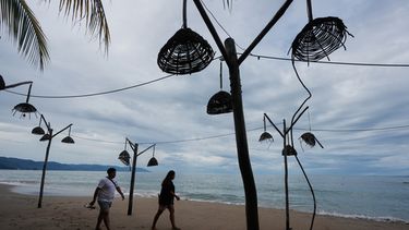 Personas caminan por la playa tras el paso del huracán Simon en Puerto Vallarta, México, el lunes 12 de octubre de 2026. (Foto AP/Fernando Llano)