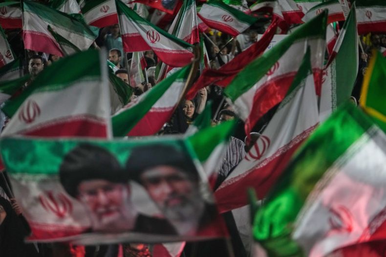 Manifestantes pro-gobierno con banderas iraníes y retratos del líder supremo ayatolá Mojtaba Jamenei (d) y su fallecido padre ayatolá Ali Jamenei, en Teherán, el 29 de mayo del 2026. (AP foto/Vahid Salemi)