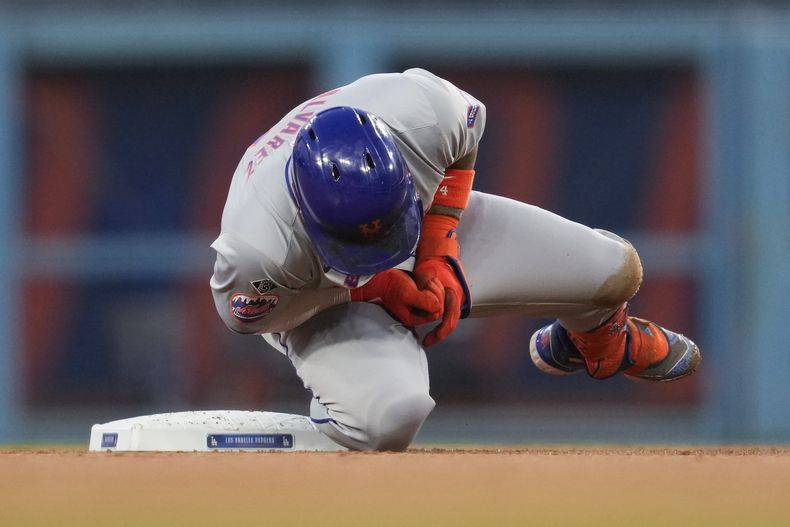 Francisco Álvarez, de los Mets de Nueva York, reacciona a una lesión en la segunda base durante la segunda entrada de un juego de béisbol contra los Dodgers de Los Ángeles en Los Ángeles, el viernes 19 de abril de 2024. (AP Foto/Ashley Landis)