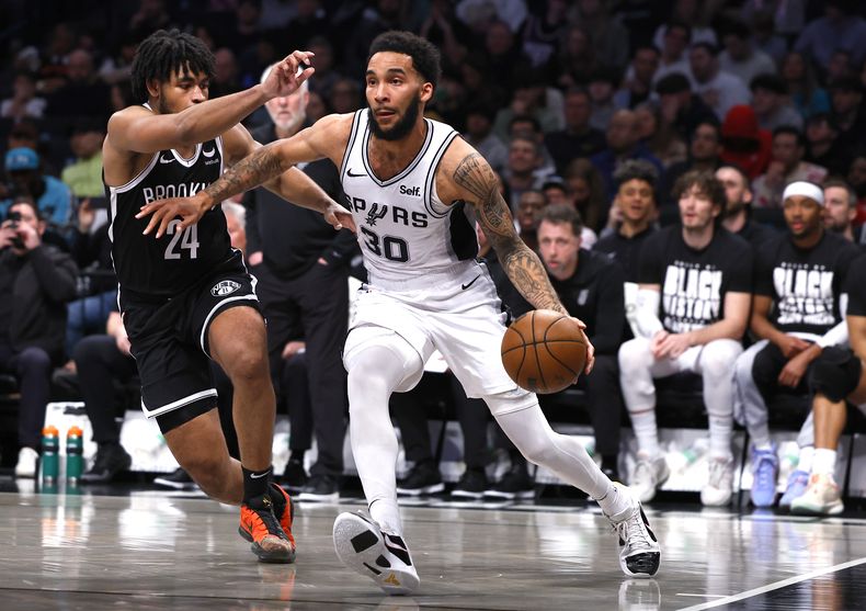 El alero de los Spurs de San Antonio, Julian Champagnie (30), conduce hacia la canasta contra el escolta de los Nets de Brooklyn, Cam Thomas (24), durante la segunda mitad deL partido de baloncesto de la NBA, el sábado 10 de febrero de 2024, en Nueva York. (AP Foto/Noah K. Murray)