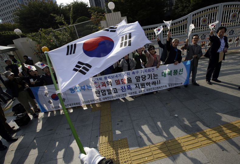 Miembros de un grupo c&iacute;vico surcoreano ondean la bandera de su pa&iacute;s mientras apoyan el env&iacute;o de globos a Norcorea con propaganda contra Pyongyang ante el complejo gubernamental de Se&uacute;l, en Corea del Sur, el 15 de octubre de 201