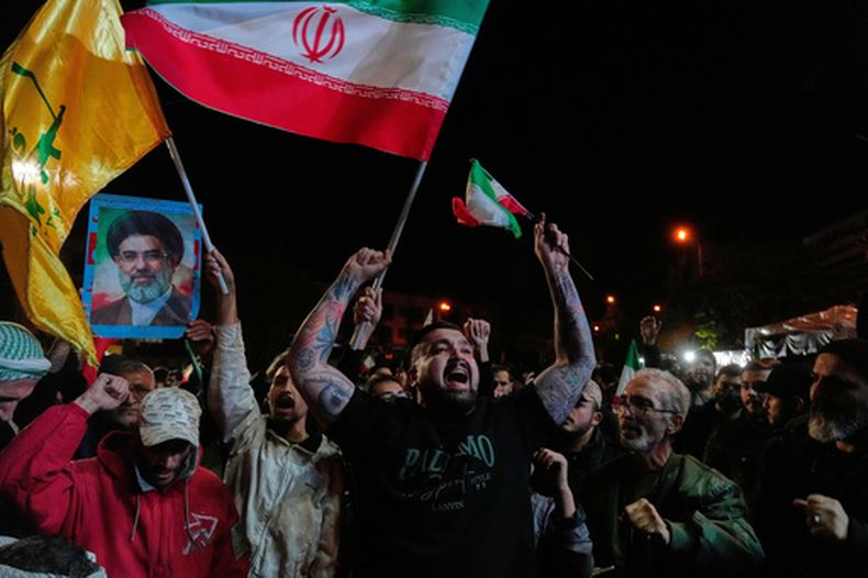 Manifestantes progubernamentales corean eslóganes mientras ondean banderas iraníes y muestran una foto del líder supremo, el ayatolá Mojtaba Jamenei, en una concentración tras el anuncio de una tregua de dos semanas en la guerra con Estados Unidos e Israel, en la Enqelab-e-Eslami, o plaza de la Revolución Islámica, en Teherán, Irán, el 8 de abril de 2026. (AP Foto/Vahid Salemi)