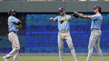 Los jardineros de los Rays de Tampa Bay, el cubano Randy Arozarena, el dominicano Jose Siri y Josh Lowe celebran la victoria en el primer juego de una doble cartelera ante los Reales de Kansas City el sábado 15 de julio del 2023. (AP Foto/Charlie Riedel)