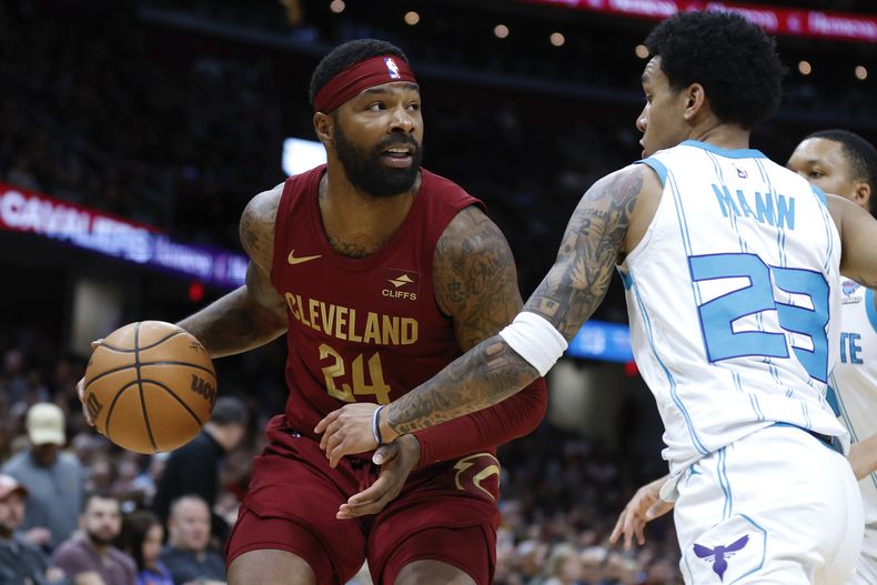El alero de los Cavaliers de Cleveland Marcus Morris Sr. avanza hacia la canasta frente al base de los Hornets de Charlotte Tre Man en el encuentro de la NBA del lunes 25 de marzo del 2024. (AP Foto/Ron Schwane)
