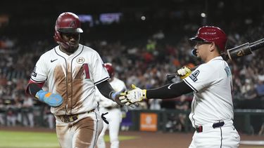 Geraldo Perdomo, izquierda, de los Diamondbacks de Arizona, celebra una carrera anotada frente a los Gigantes de San Francisco con su compañero Ildemaro Vargas, derecha, durante la primera entrada del juego de béisbol de Grandes Ligas, el lunes 15 de septiembre de 2025, en Phoenix. (AP Foto/Ross D. Franklin)
