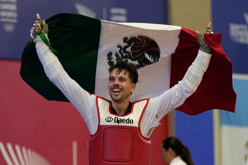 El mexicano Iker Casas celebra tras derrotar al colombiano Miguel Trejos en la final de los -80kg del taekwondo de los Juegos Centroamericanos y del Caribe, el lunes 27 de julio de 2026, en Santo Domingo, República Dominicana. (AP Foto/Fernando Vergara)