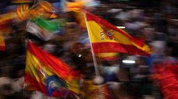 Simpatizantes del Partido Popular ondean banderas de España mientras esperan la comparecencia de su candidato a la presidencia, Alberto Núñez Feijóo, en el exterior de la sede de la formación conservadora durante la noche electoral, el 23 de julio de 2023, en Madrid. (AP Foto/Manu Fernández)