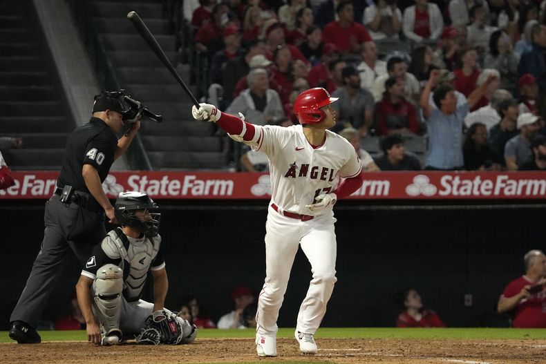 Shohei Ohtani de los Angelinos de Los Ángeles avanza a primera tras conectar un jonrón frente al cátcher de los Medias Blancas de Chicago Yasmani Grandal y el umpire Roberto Ortiz en la séptima entrada del juego del martes 27 de junio del 2023. (AP Foto/Mark J. Terrill)