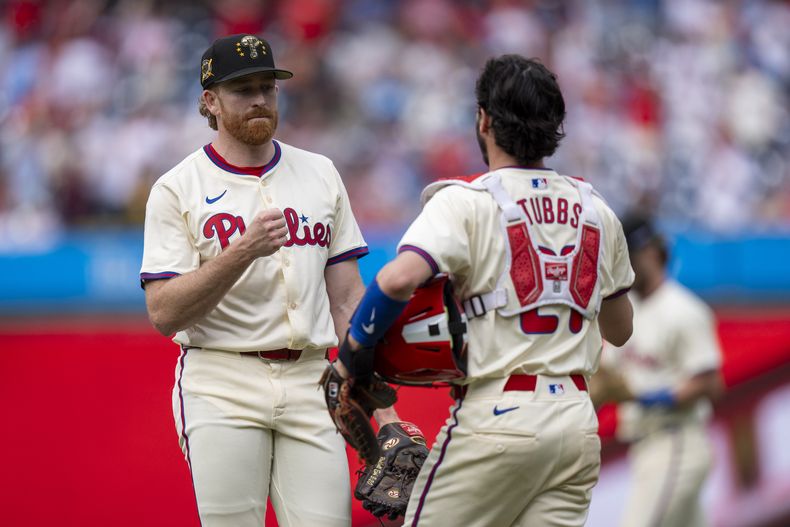 El lanzador abridor de los Filis de Filadelfia, Spencer Turnbull, a la izquierda, celebra después de una victoria con el receptor Garrett Stubbs, a la derecha, después de un partido de béisbol contra los Nacionales de Washington, el domingo 19 de mayo de 2024, en Filadelfia. (AP Foto/Chris Szagola)