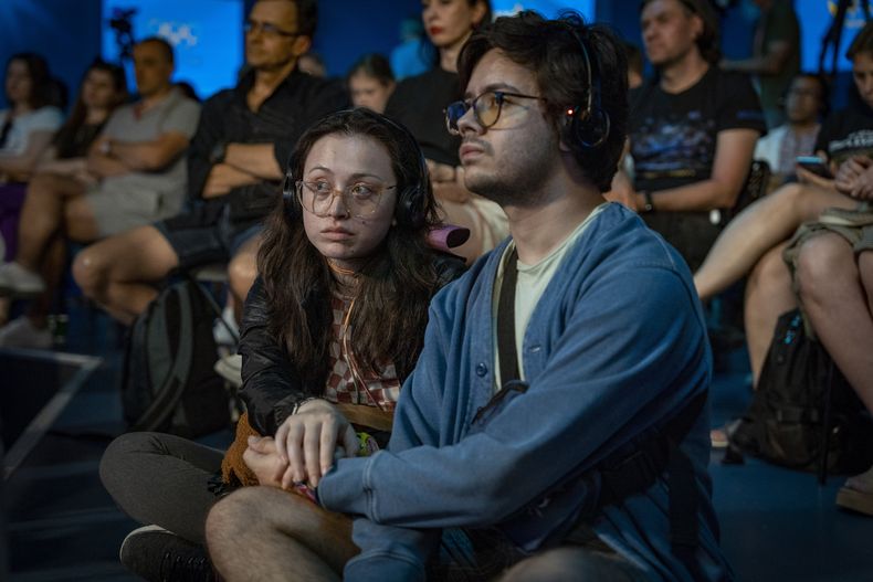 Un grupo de personas escucha una charla pública en la Casa de Ucrania en París, Francia, el domingo 4 de agosto de 2024. (AP Foto/Hanna Arhirova)