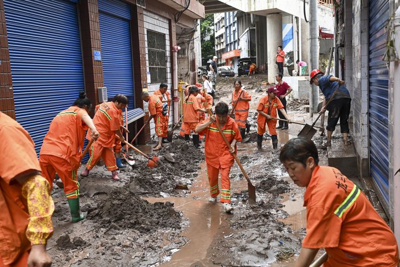 En esta imagen publicada por la agencia de noticias china Xinhua, trabajadores limpiando lodo y restos de una calle en el distrito de Wanzhou, en Chongqing, China, el martes 4 de julio de 2023. (Ran Mengjun/Xinhua via AP)
