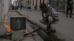 Un hombre cocina sopa sobre una fogata en una acera durante un apagón en La Habana, Cuba, el miércoles 4 de diciembre de 2024. (AP Foto/Ramón Espinosa) Un hombre cocina sopa sobre una fogata en una acera durante un apagón en La Habana, Cuba, el miércoles 4 de diciembre de 2024. (AP Foto/Ramón Espinosa)