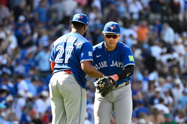 El primera base de los Azulejos de Toronto, Vladimir Guerrero Jr. (27), y el tercera base japonés Kazuma Okamoto (derecha) se abrazan después de un partido de béisbol contra los Cachorros de Chicago, el sábado 20 de junio de 2026, en Chicago. (Foto AP/Matt Marton)