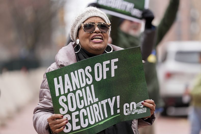 Manifestantes se congregan afuera del tribunal de distrito de Baltimore, el viernes 14 de marzo de 2025, previo a una audiencia relacionada con el Departamento de Eficiencia Gubernamental. (AP Foto/Stephanie Scarbrough)