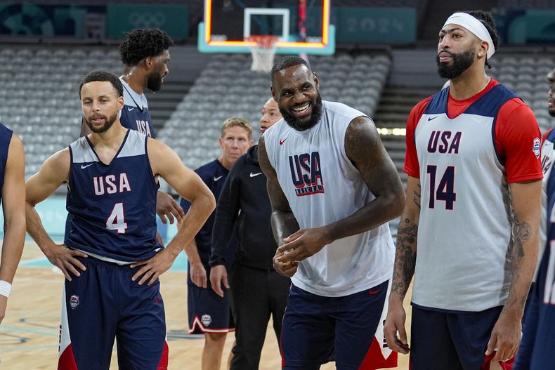 LeBron James, se ríe con Stephen Curry y Anthony Davis durante una práctica antes de iniciar el torneo de baloncesto de los Juegos Olímpicos el miércoles 24 de julio del 2024 en Villeneuve-dAscq, Francia. (AP Foto/Michael Conroy)