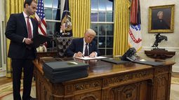 El presidente Donald Trump firma una orden ejecutiva en la Oficina Oval de la Casa Blanca, el lunes 20 de enero de 2025, en Washington. (AP Foto/Evan Vucci)