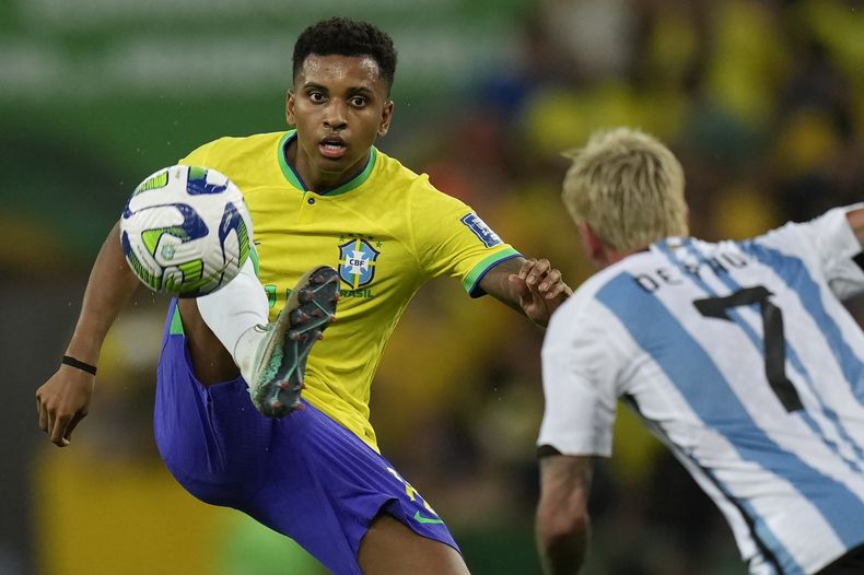 Rodrygo, de la selección de Brasil, controla un balón frente a Rodrigo de Paul, de Argentina, durante un partido de la eliminatoria mundialista en Río de Janeiro, el martes 21 de noviembre de 2023 (AP Foto/Silvia Izquierdo)
