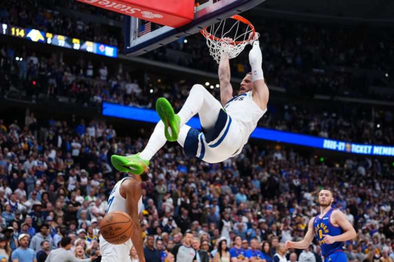 Donte DiVincenzo (0), de los Timberwolves de Minnesota, retaca el balón frente a los Nuggets de Denver durante la segunda mitad del juego de baloncesto de primera ronda de los playoffs de la NBA, el lunes 20 de abril de 2026, en Denver. (AP Foto/Jack Dempsey)