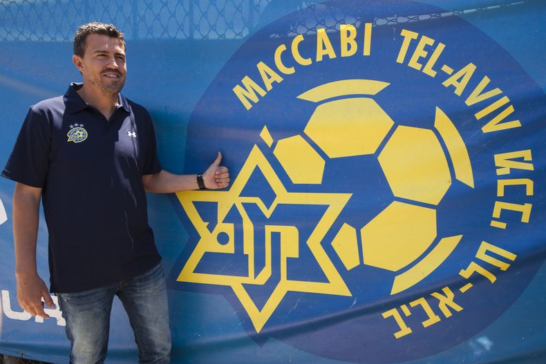 El t&eacute;cnico de Maccabi Tel Aviv, Oscar Garc&iacute;a, posa al lado del escudo del club el jueves, 31 de mayo de 2012. Garc&iacute;a renunci&oacute; al cargo el 26 de agosto de 2014, por la situaci&oacute;n de inseguridad en Israel.  (AP Photo/Ariel