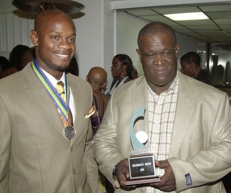 ARCHIVO - Foto del 23 de febrero del 2006, el velocista Asafa Powell junto con su entrenador Stephen Francis tras recibir el galardón tras ganar el premio al deportista de Jamaica del 2005. (AP Foto/Collin Reid, Archivo)