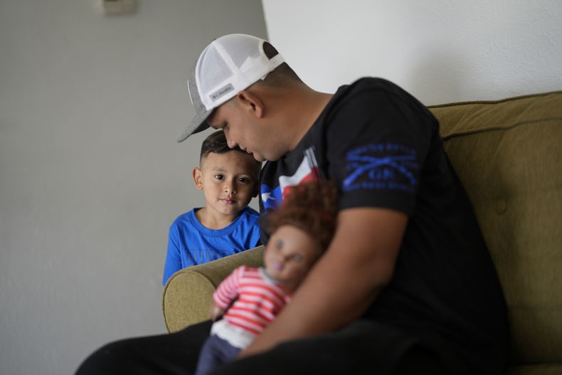 Alexis Llanos, de 27 años, interactúa con su hijo Alexis, de 3 años, dentro de la casa de Lehigh Acres, en Florida, a la que se mudaron en octubre de 2023, cinco años después de haber salido de Venezuela hacia Colombia por amenazas de muerte, el 27 de diciembre de 2023. La de Llanos es una de las primeras familias de migrantes que llegaron a Estados Unidos legalmente bajo un nuevo programa conocido como Oficinas de Movilidad Segura, que busca agilizar el proceso de refugiados. (AP Foto/Rebecca Blackwell)