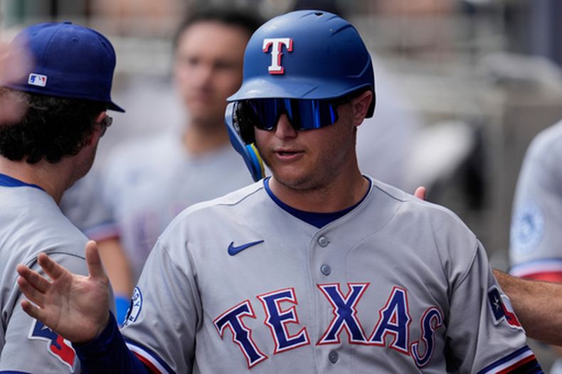 El bateador designado de los Rangers de Texas, Joc Pederson (3), celebra haber anotado gracias a un batazo de Brandon Nimmo en la tercera entrada de un partido de béisbol contra los Bravos de Atlanta, el sábado 18 de julio de 2026, en Atlanta. (Foto AP/Mike Stewart)