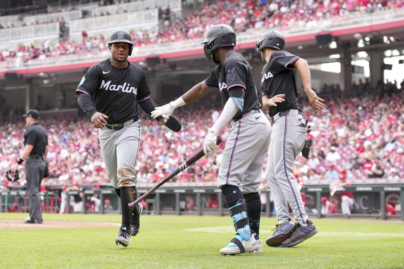 Xavier Edwards de los Marlins de Miami celebra con sus compañeros Vidal Bruján y Jonah Bride su sencillo en la quinta entrada ante los Rojos de Cincinnati el domingo 14 de julio del 2024. (AP Foto/Jeff Dean)