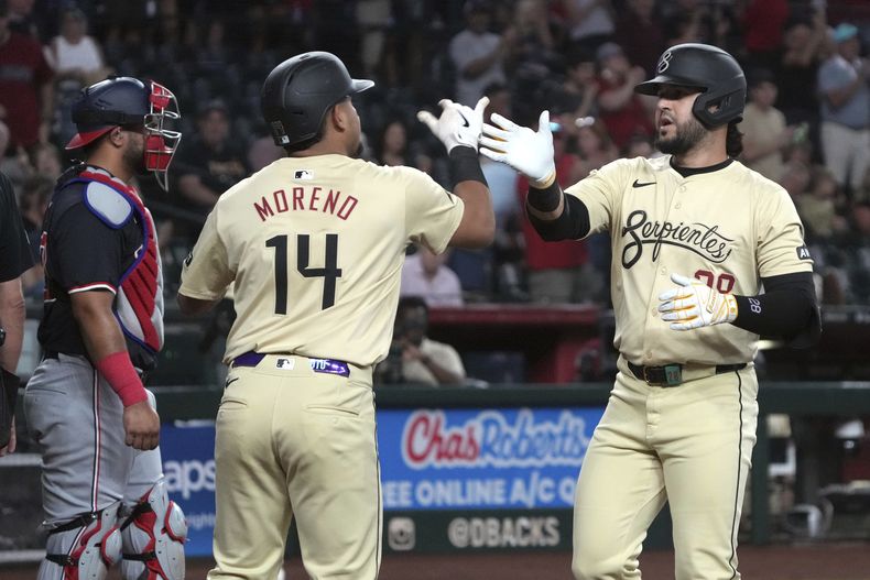 Eugenio Suárez de los Diamondbacks de Arizona celebra con Gabriel Moreno tras batear un jonrón de dos carreras en la primera entrada ante los Nacionales de Washington el martes 30 de julio del 2024. (AP Foto/Rick Scuteri)