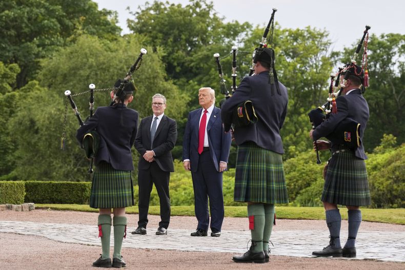 El presidente de Estados Unidos, Donald Trump, tercero por la derecha, y el primer ministro británico, Keir Starmer, cuarto por la derecha, son recibidos en el Trump International Golf Links, cerca de Aberdeen, Escocia, el lunes 28 de julio de 2025. (AP Foto/Jacquelyn Martin)