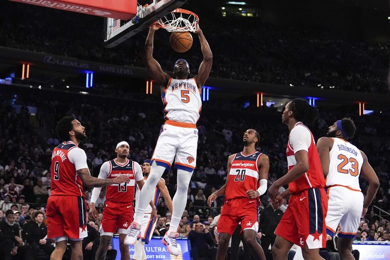 El alero de los Knicks de Nueva York, Precious Achiuwa (5), hace una clavada durante la primera mitad de un partido de baloncesto de la NBA contra los Wizards de Washington, el sábado 22 de marzo de 2025, en Nueva York. (AP Foto/Julia Demaree Nikhinson)