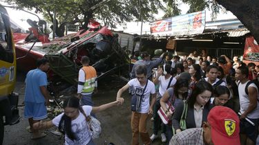 americateve | Vista de los restos de un autob&uacute;s de pasajeros que se precipit&oacute; desde una carretera elevada para incrustarse en una camioneta que pasaba por debajo en el suburbio de Paranaque, cerca de Manila, Filipinas, el lunes 16 de diciembre del 2013. E