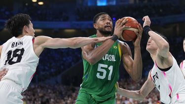 El brasileño Bruno Caboclo se abre espacio entre los japoneses Yudai Baba (izquierda) y Yuta Watanabe en el torneo de baloncesto de los Juegos Olímpicos de París, el viernes 2 de agosto de 2024, en Villeneuve-dAscq, Francia. (AP Foto/Mark J. Terrill)