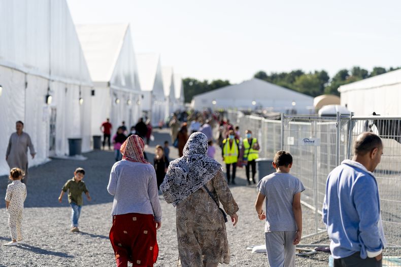 Refugiados afganos caminan por un campamento para ellos en la Base McGuire Dix, el 27 de septiembre de 2021, en Lakehurst, Nueva Jersey. (AP Foto/Andrew Harnik, archivo)