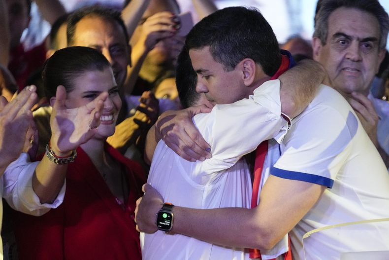 Santiago Peña, candidato presidencial del gobernante Partido Colorado, a la derecha, abraza al expresidente Horacio Cartes tras el cierre de la votación de las elecciones generales en Asunción, Paraguay, el domingo 30 de abril de 2023. (AP Foto/Jorge Sáenz)